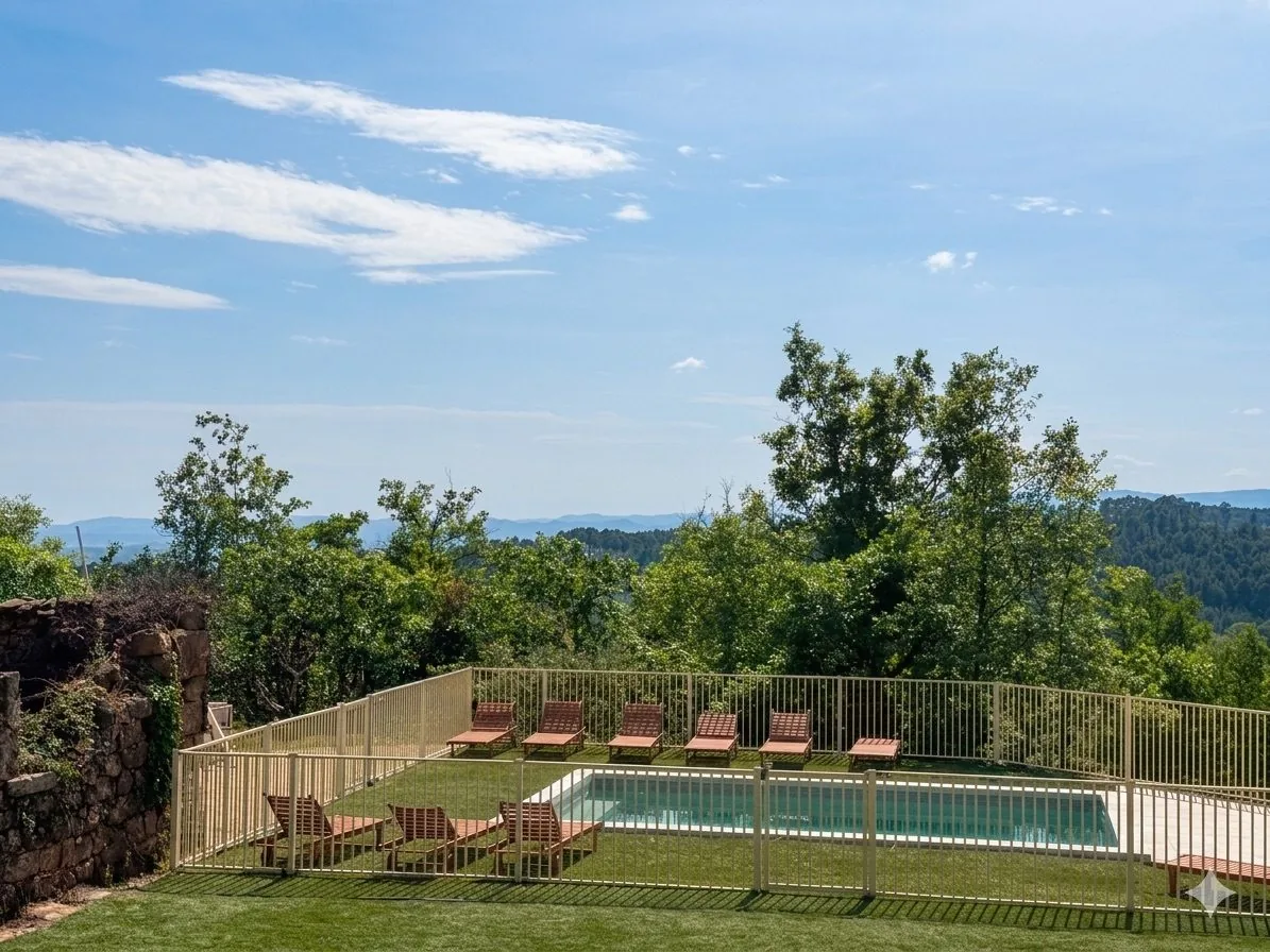 La piscine privée et ses transats face aux collines de l'Ardèche